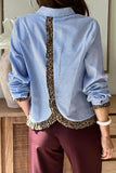 Person wearing a blue striped shirt with leopard print trim and maroon pants.