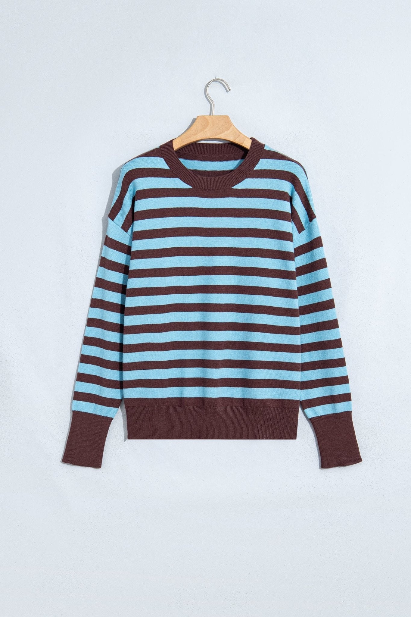 Long-sleeve striped sweater in light blue and dark brown on a wooden hanger.