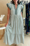 Woman wearing a green and white striped dress in a clothing store.