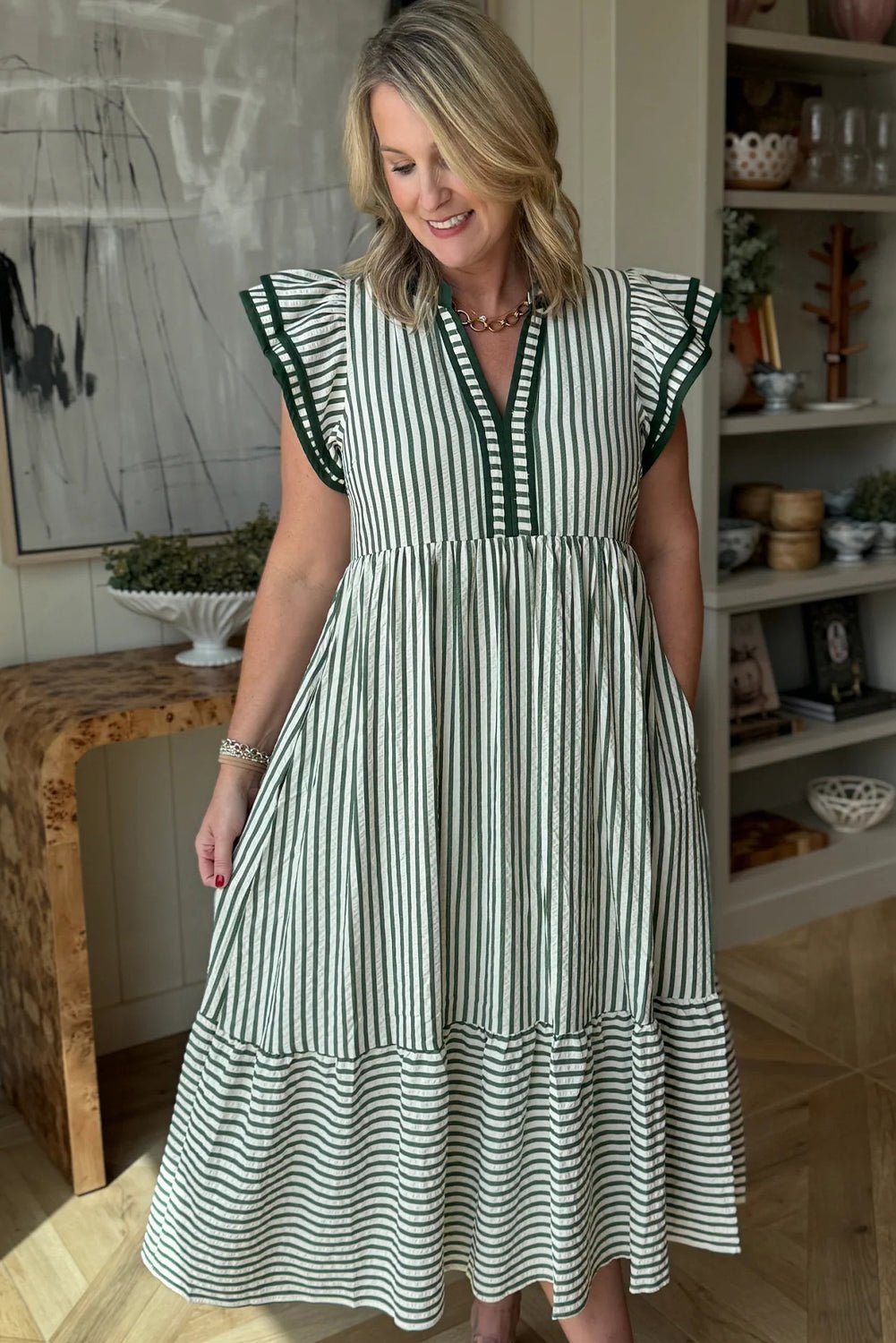 Woman wearing a black and white striped dress in an indoor setting.