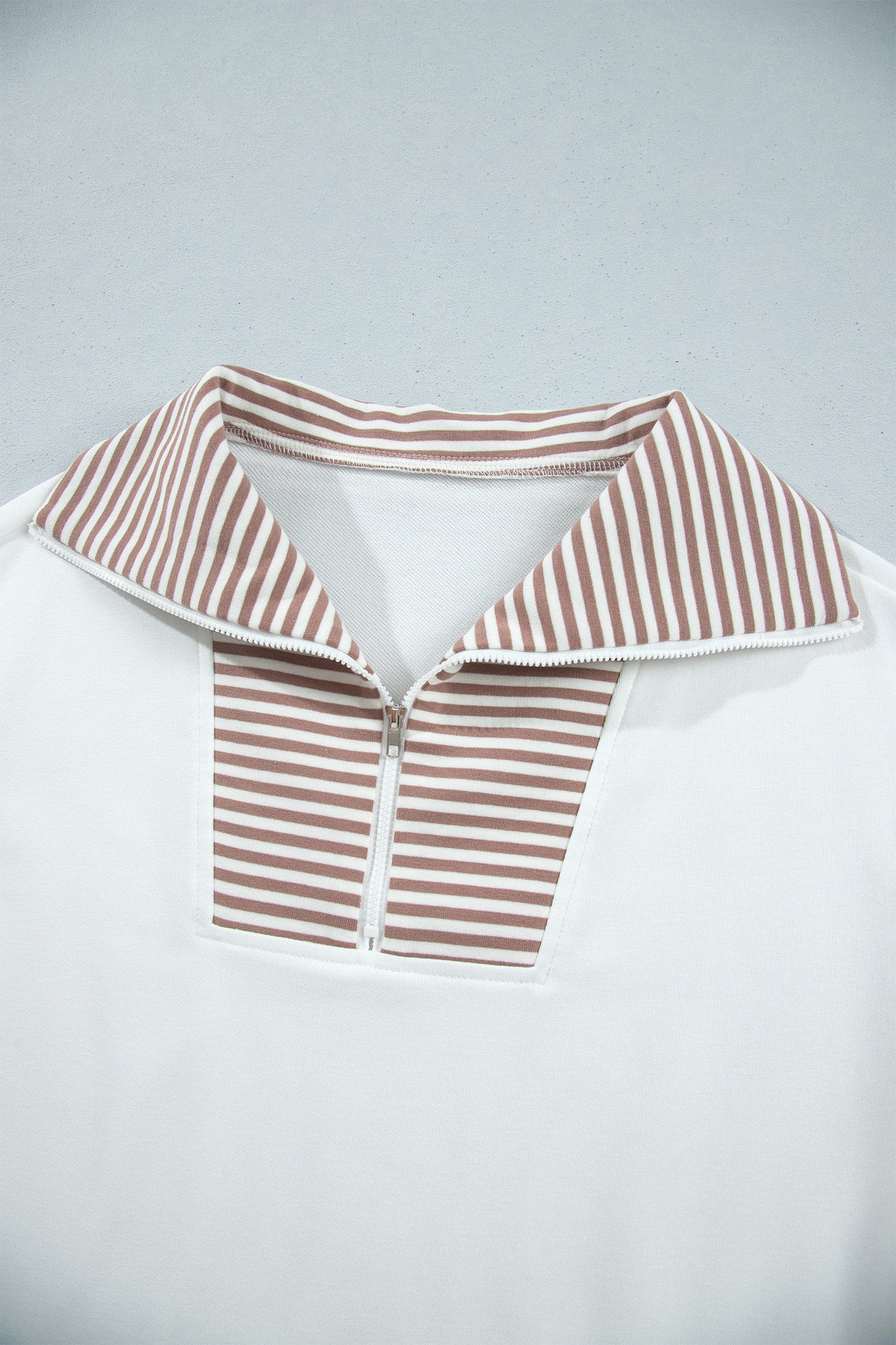 Wide striped fold-over collar and half zip neckline detail
