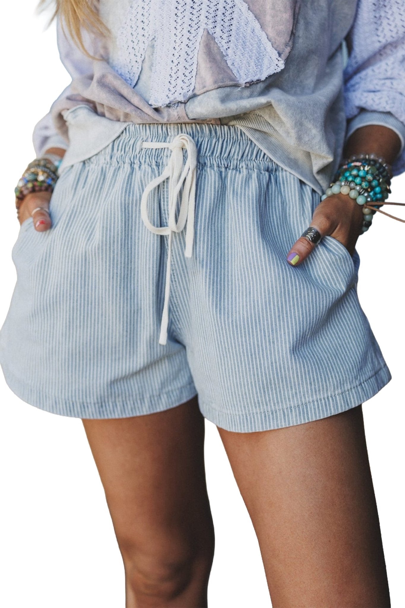 Person wearing light blue striped shorts with a white background