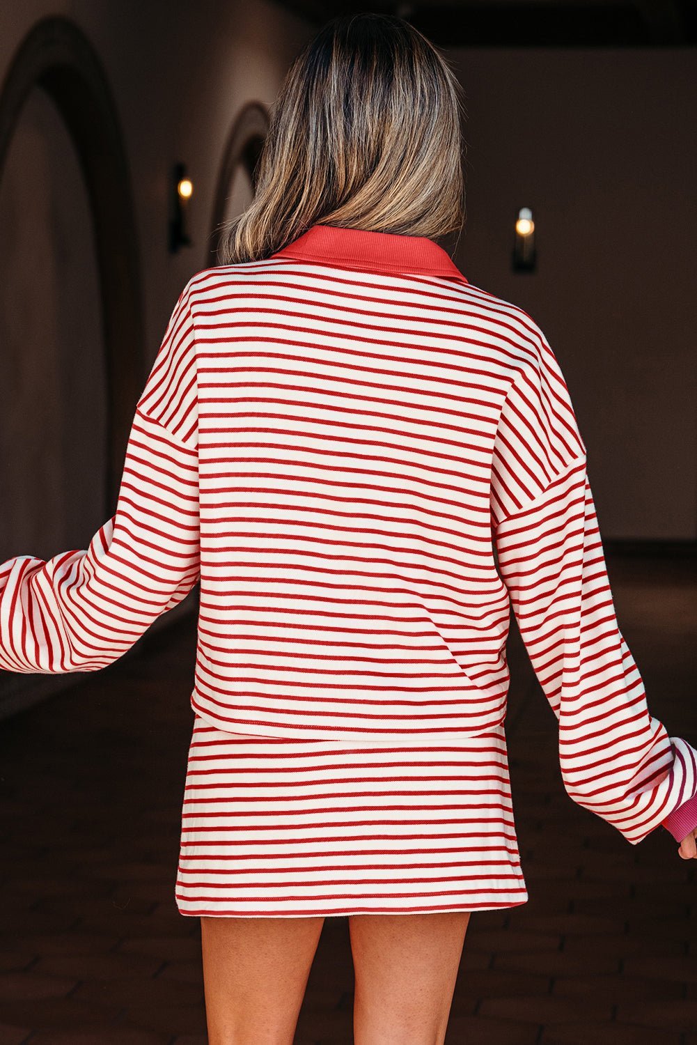 Person wearing a red and white striped dress with a blurred background