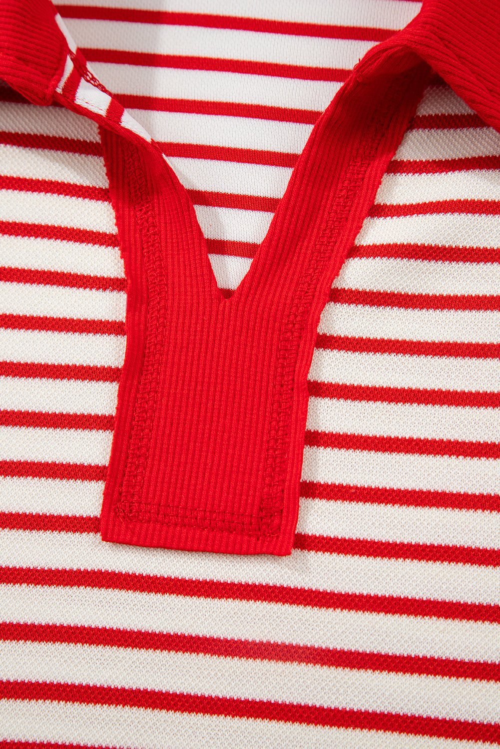 Close-up of a red and white striped garment with a V-neck design.