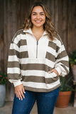 Woman in brown and white striped quarter-zip with blue jeans.