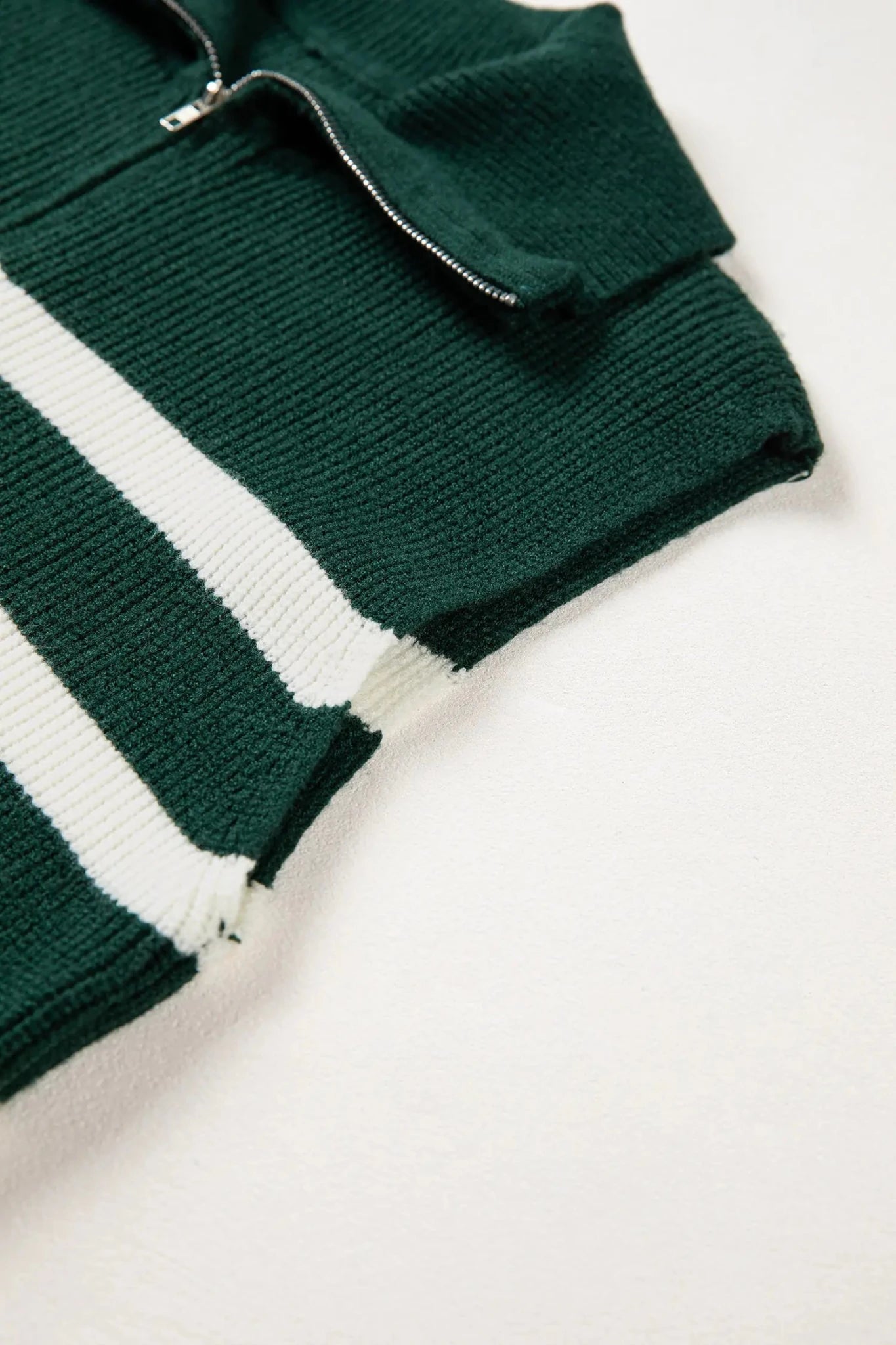 Green and white striped sweater on a light background