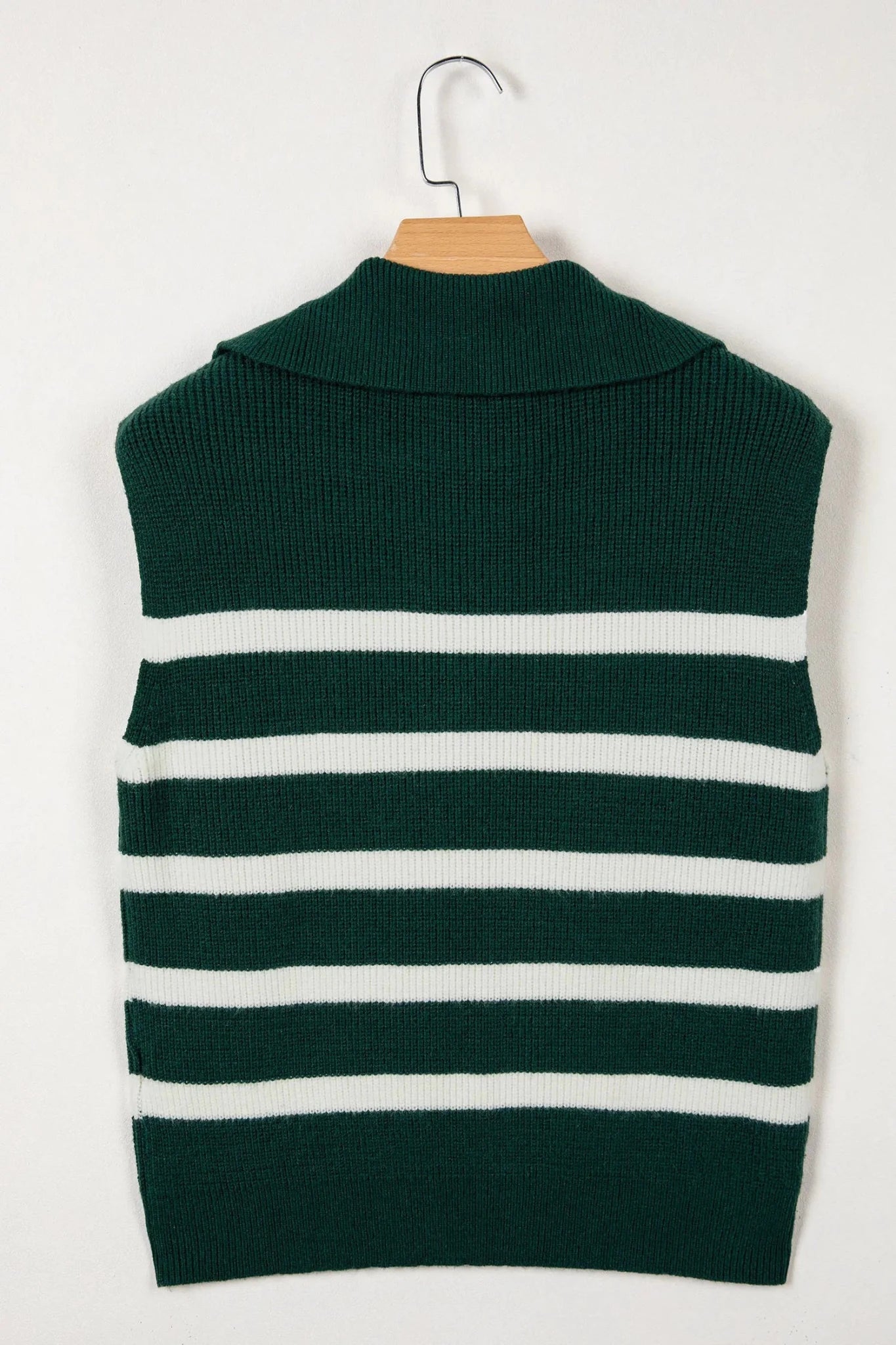Green and white striped sweater vest on a hanger against a white background