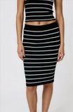 Person wearing a black and white striped top and skirt on a white background