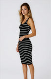 Woman wearing a black and white striped dress against a plain background