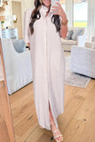 Woman taking a mirror selfie wearing a long, light-colored dress in a living room.