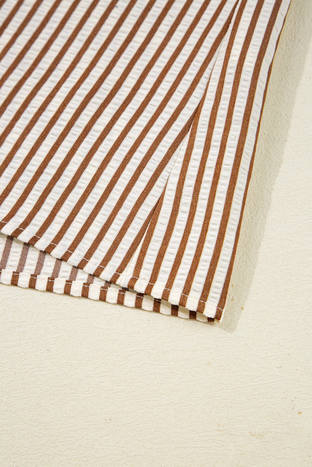 Close-up of brown and white striped fabric on a beige background