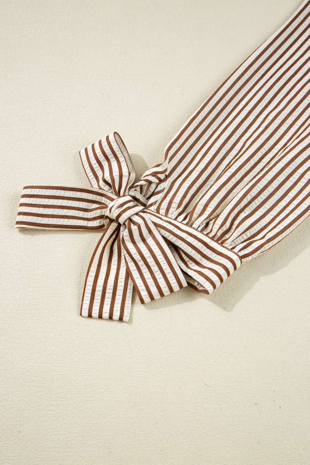Striped headband with a bow on a beige background