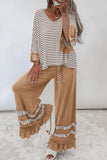 Woman wearing a brown striped top with ruffled cuffs and wide-leg tan fringe pants.