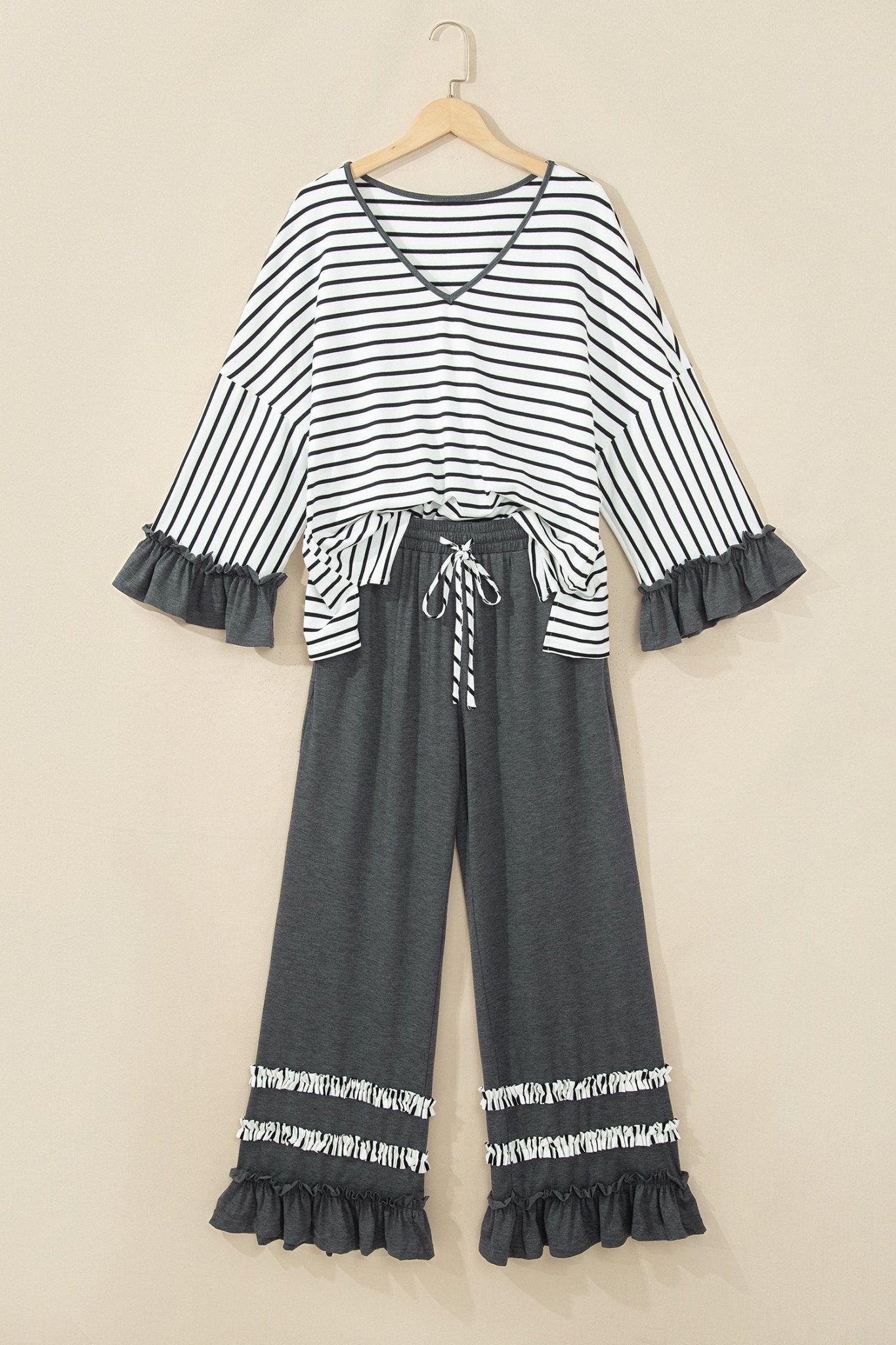 Two-piece women's set with striped crop top, gray wide-leg pants, belt, and ruffled hems.