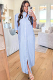 Woman taking a mirror selfie wearing a blue and white striped dress in a living room.