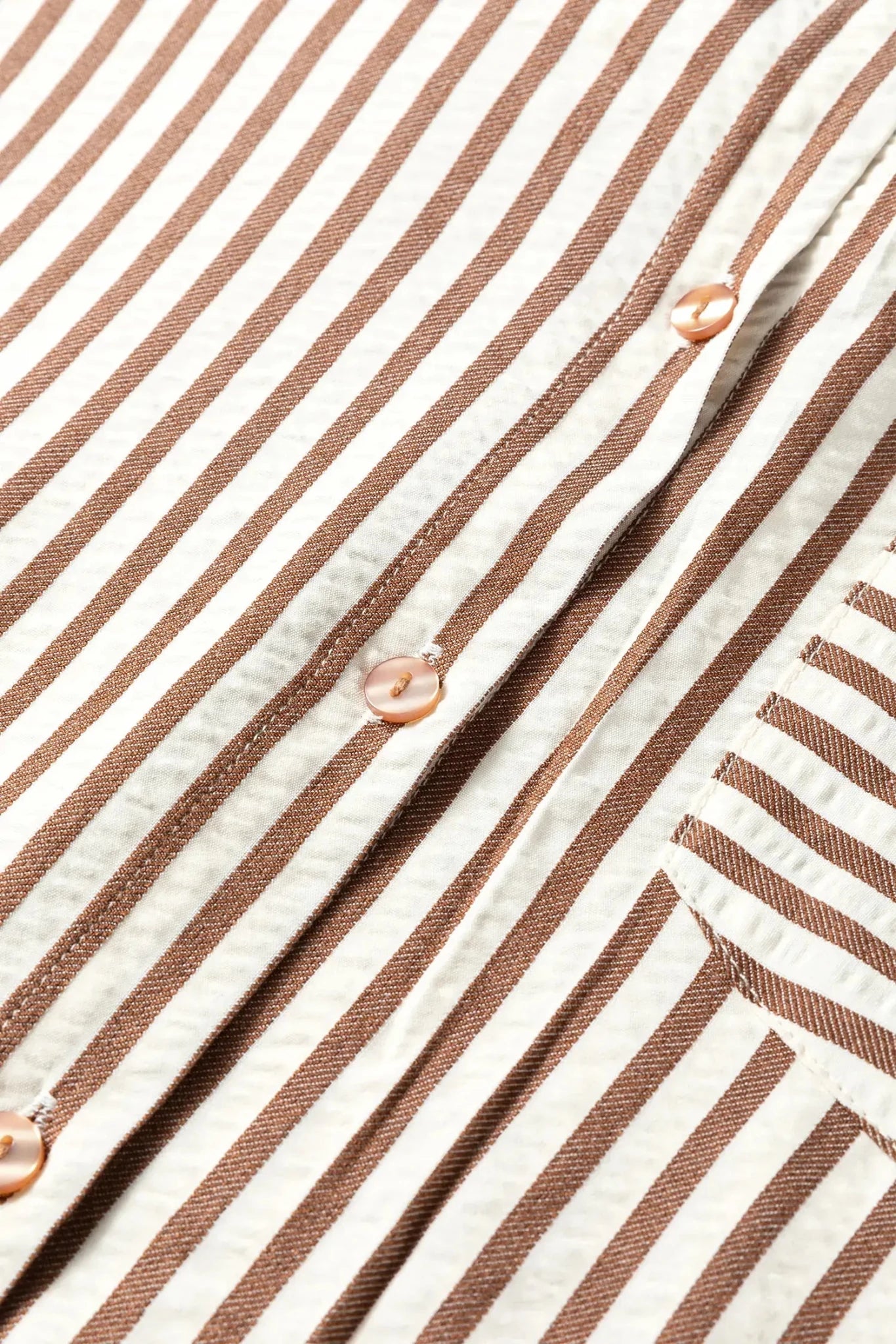 Close-up of a brown and white striped fabric with buttons.