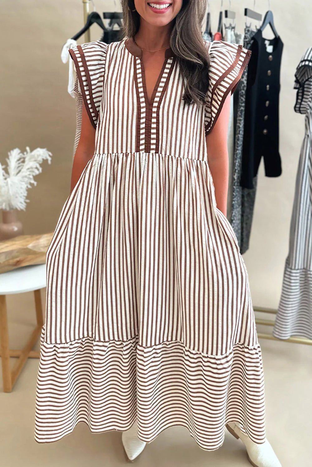 Woman wearing a brown and white striped dress in a clothing store.