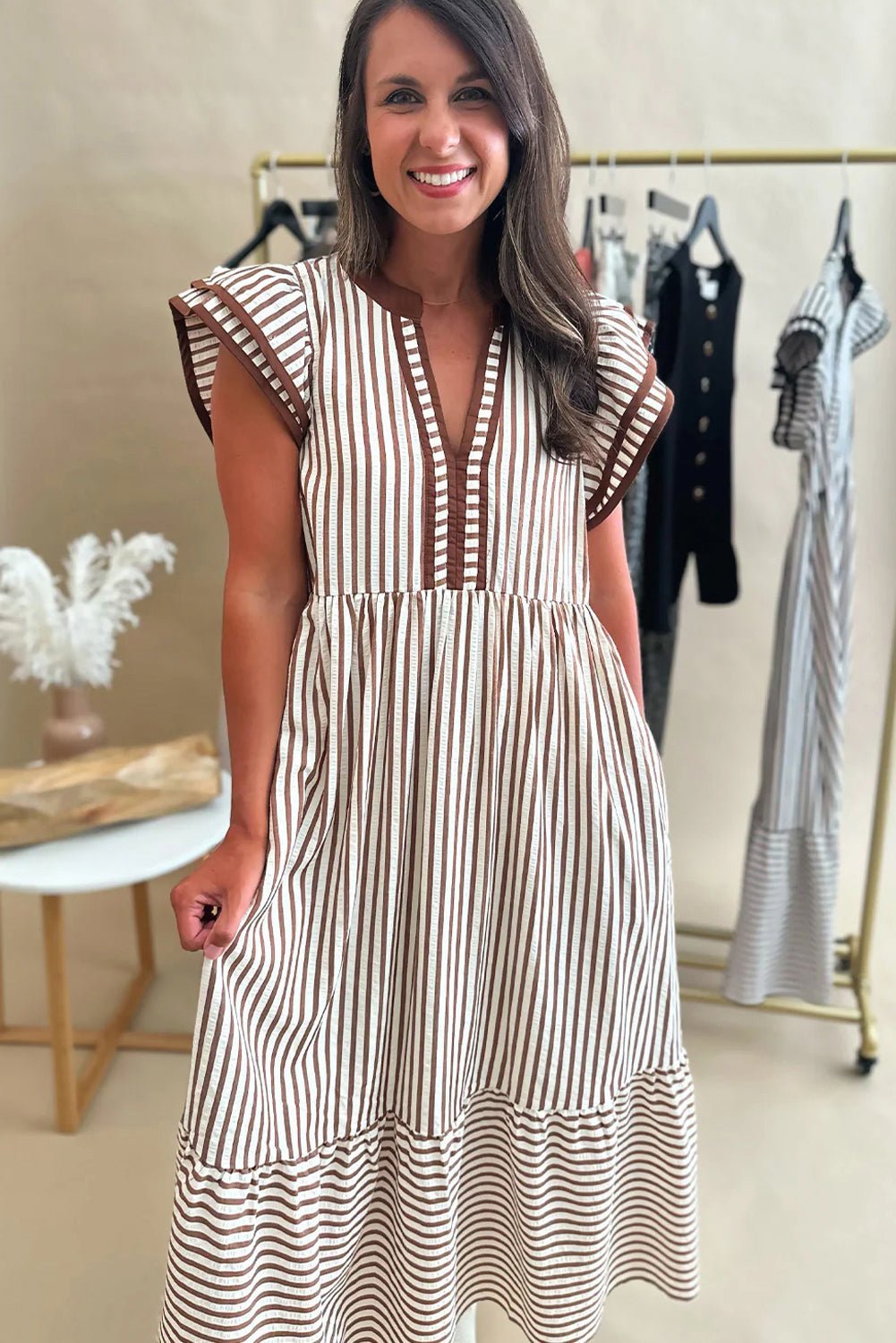 Woman wearing a striped dress in a clothing store setting