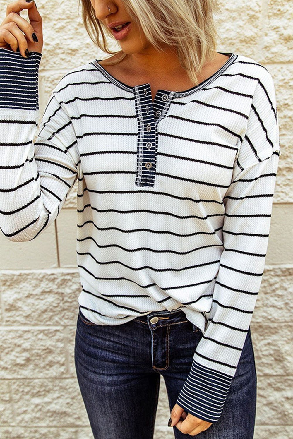 Person wearing a black and white striped long-sleeve shirt with a textured pattern.