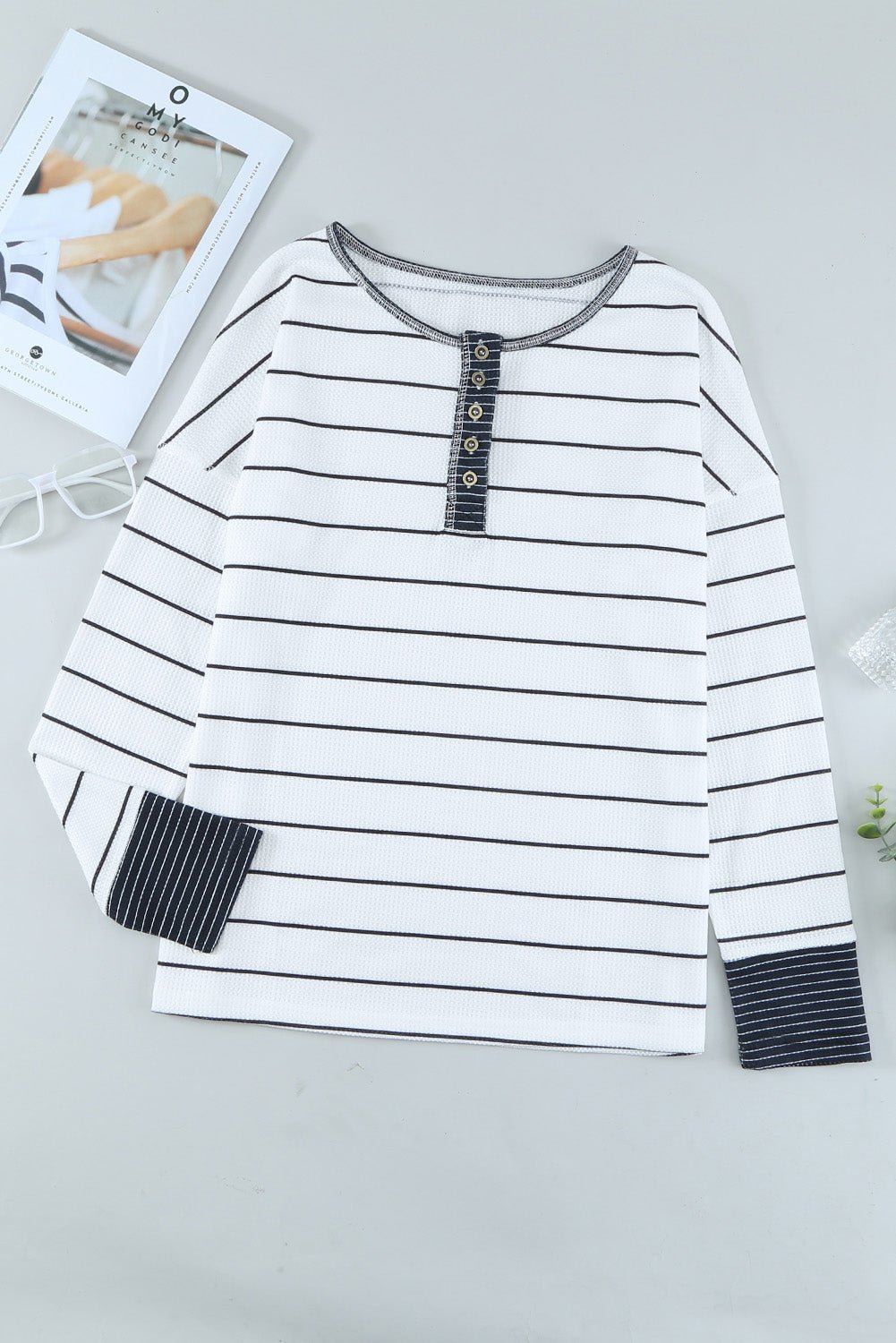 Black and white striped long-sleeve shirt on a light gray background