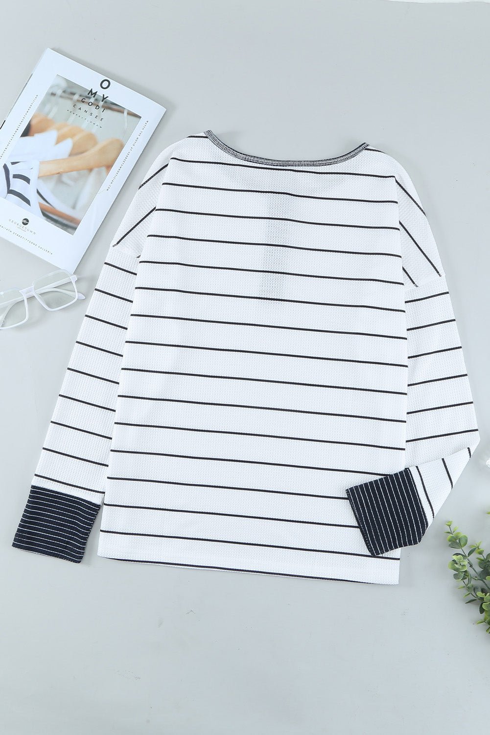 White long-sleeve shirt with black stripes on a light gray background