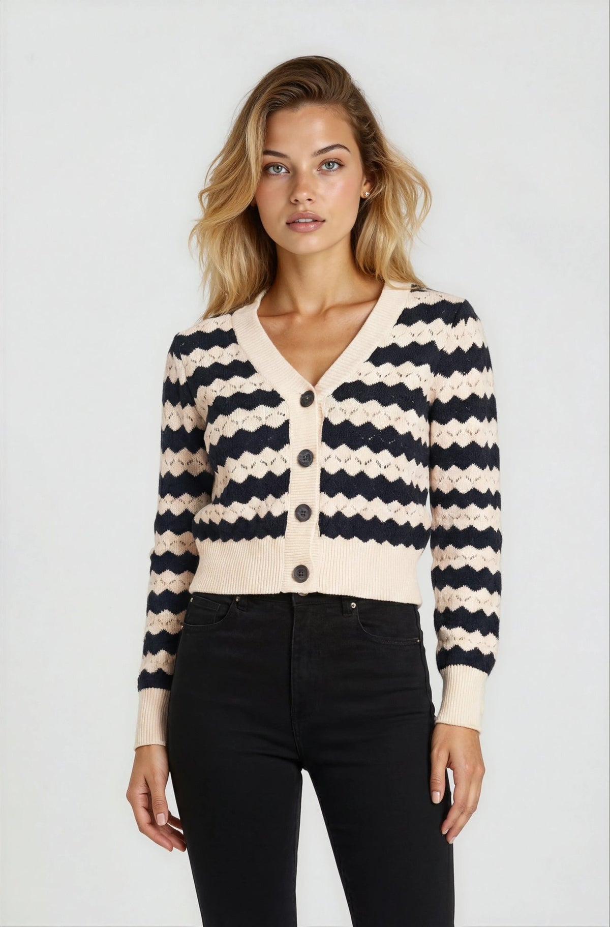 Woman wearing a black and white striped cardigan on a plain background
