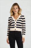 Woman wearing a black and white striped cardigan on a plain background