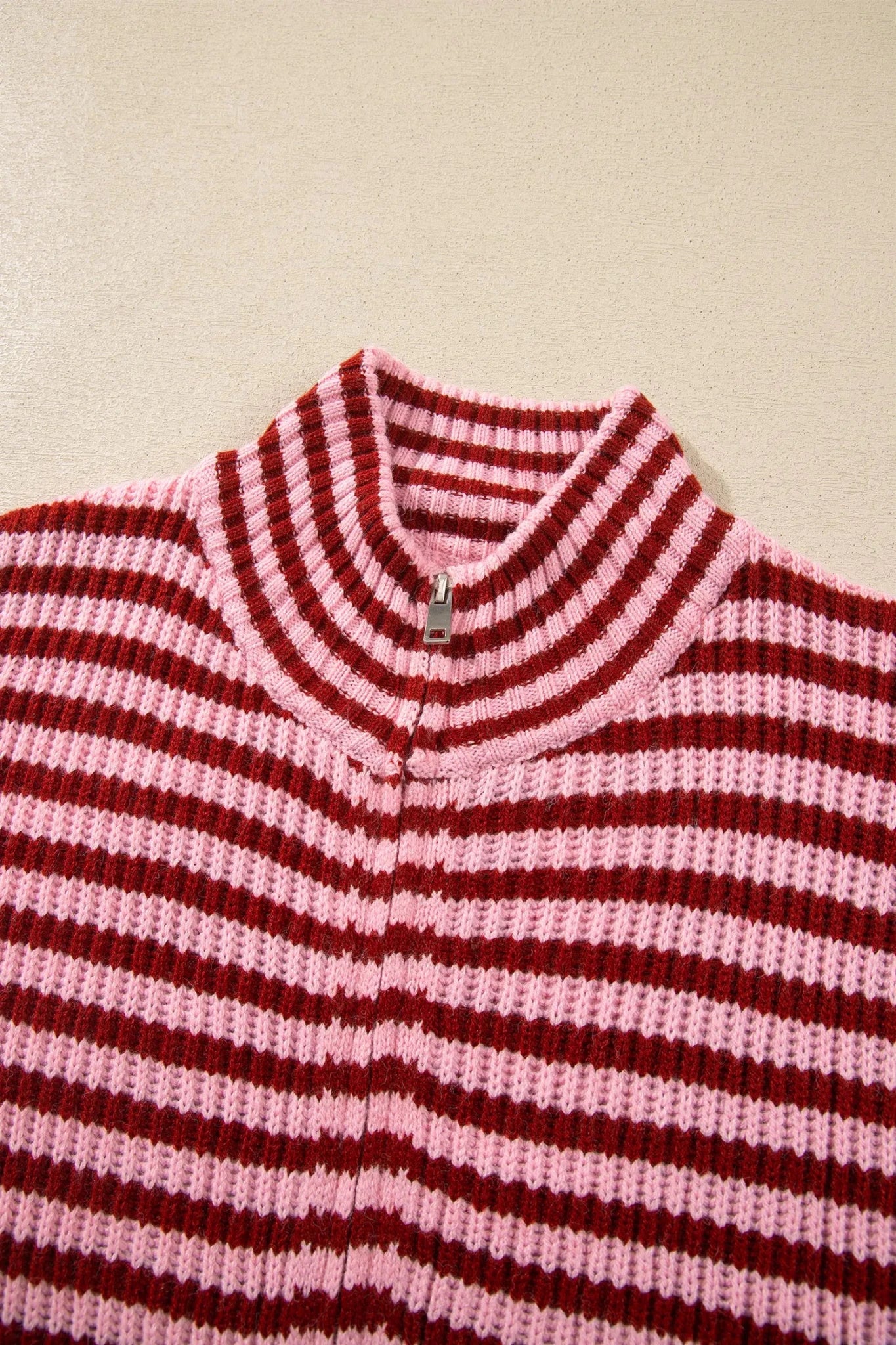 Close-up of dark red and light pink striped knit mock-neck sweater.