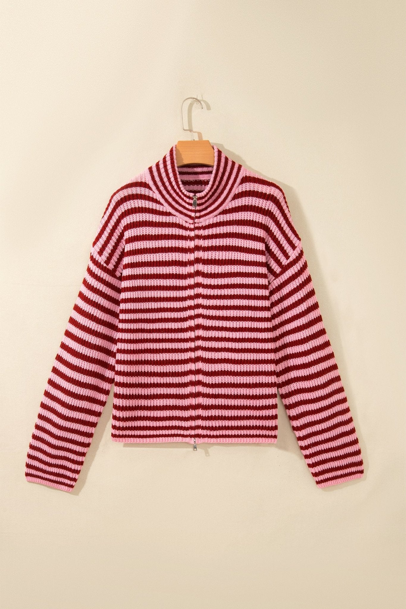 Red-white striped knit zip-up sweater with mock neck on wooden hanger.
