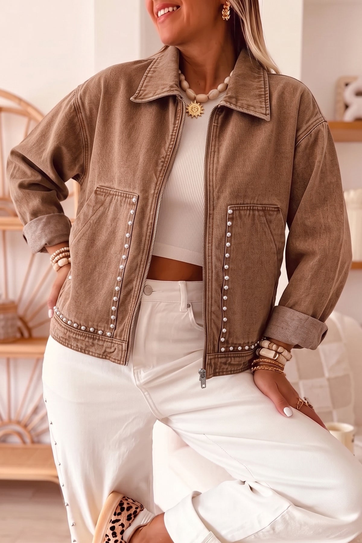 Women's coffee brown studded pocket cropped denim jacket with white pants, front view