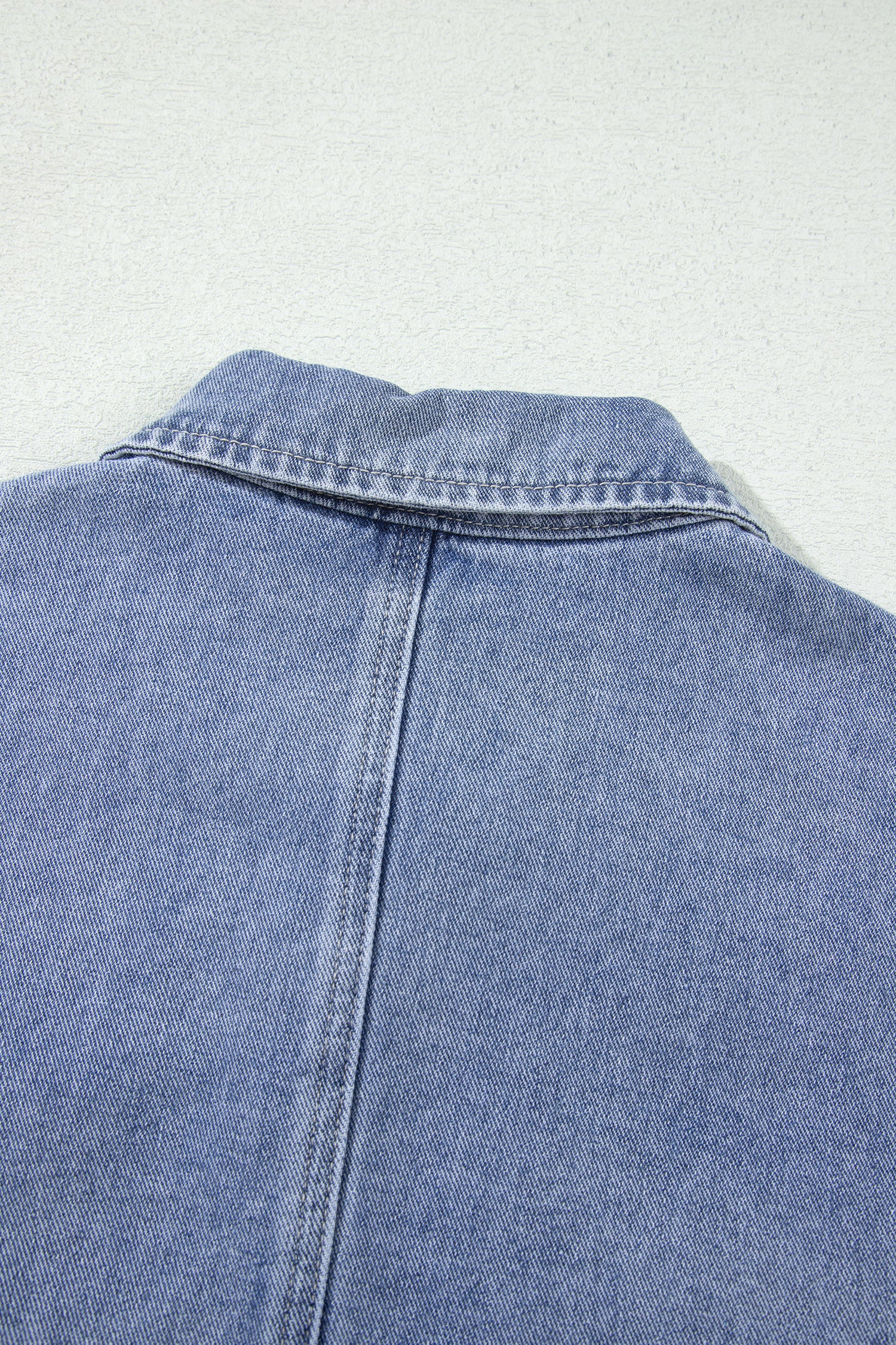 Light blue denim jacket back collar and center seam detail
