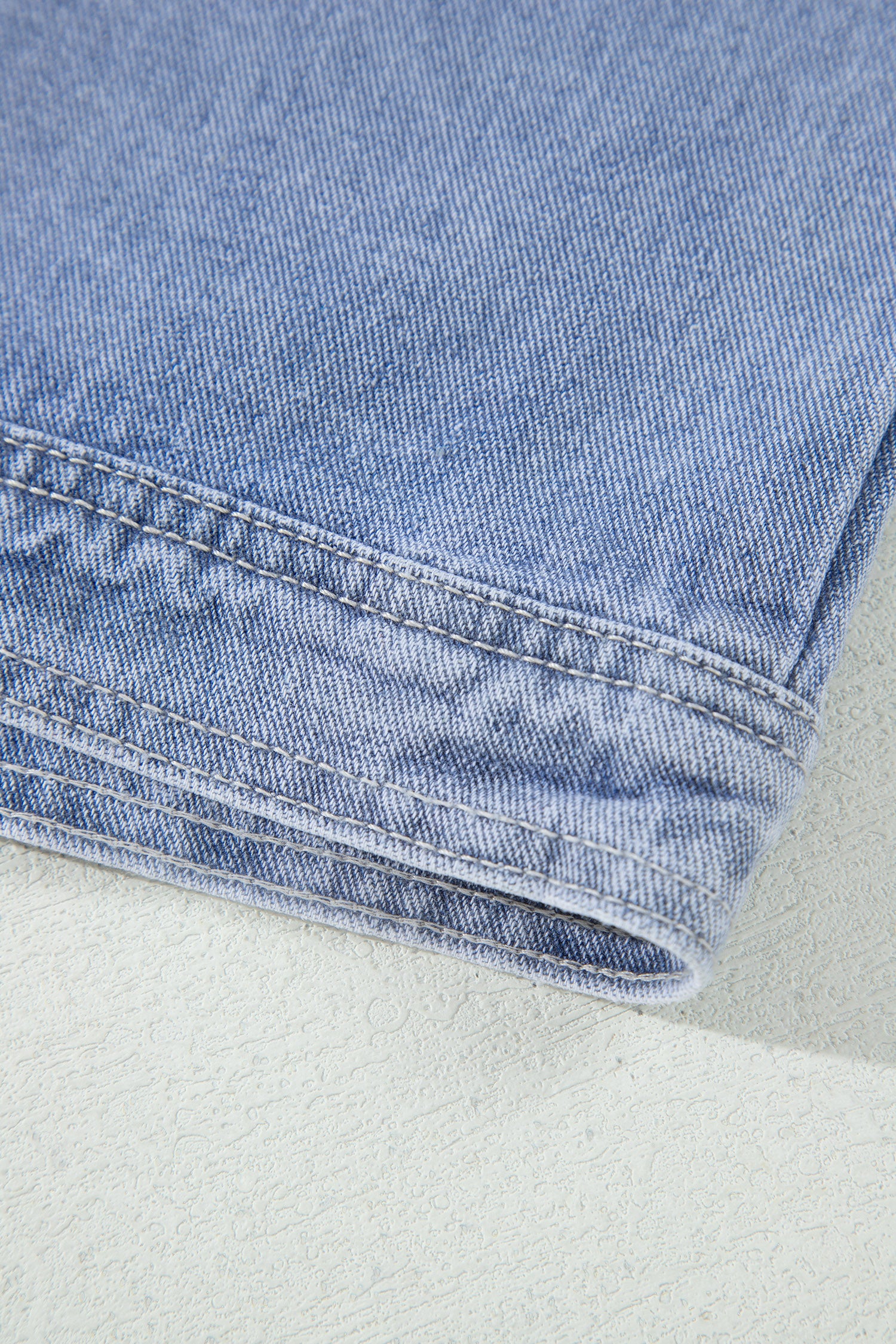 Light blue denim jacket hem stitching close-up