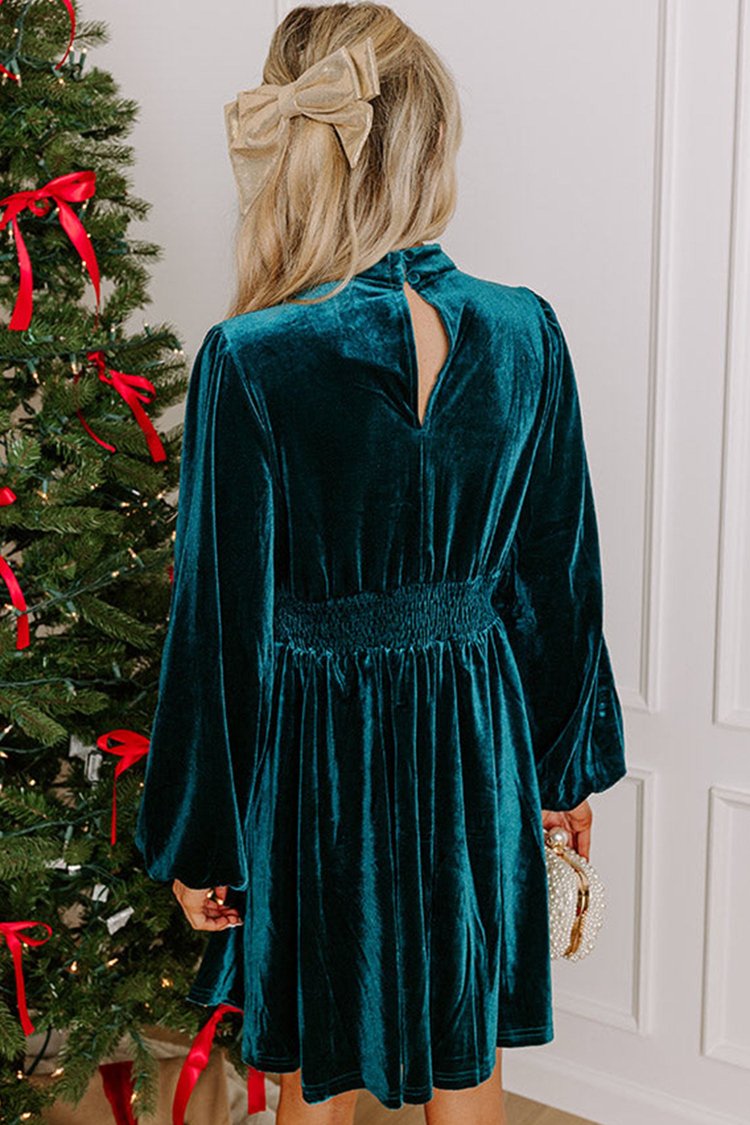 Back view of teal velvet mini dress with button keyhole and smocked waist