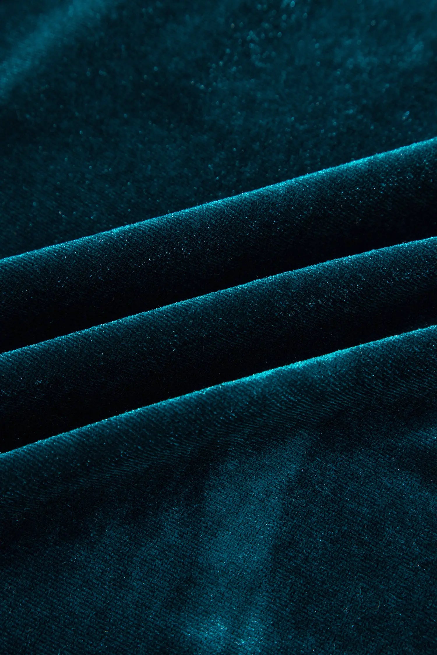 Close-up of soft teal stretch velvet with a rich sheen