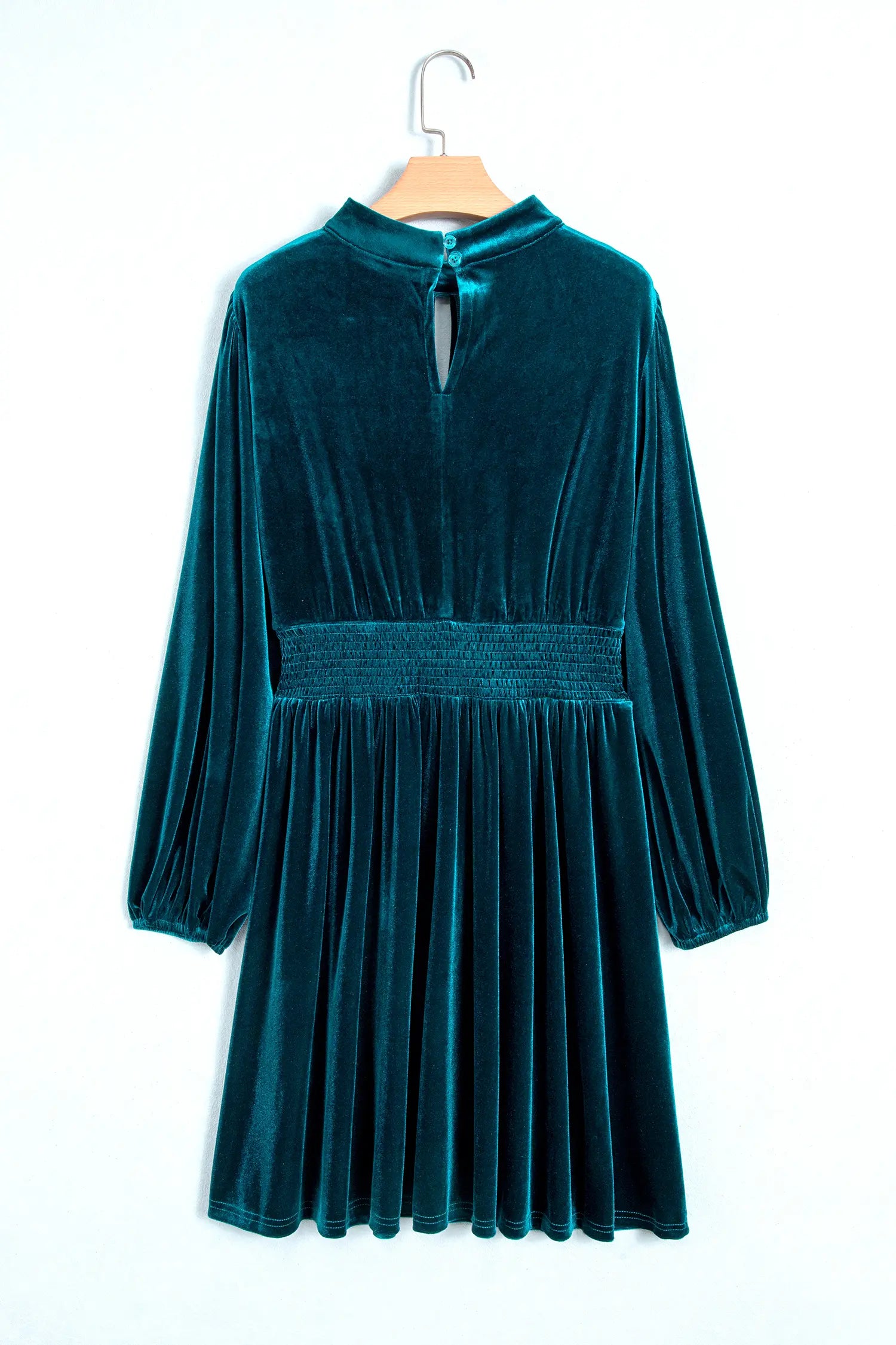 Teal velvet mini dress with keyhole back and smocked waist on a hanger