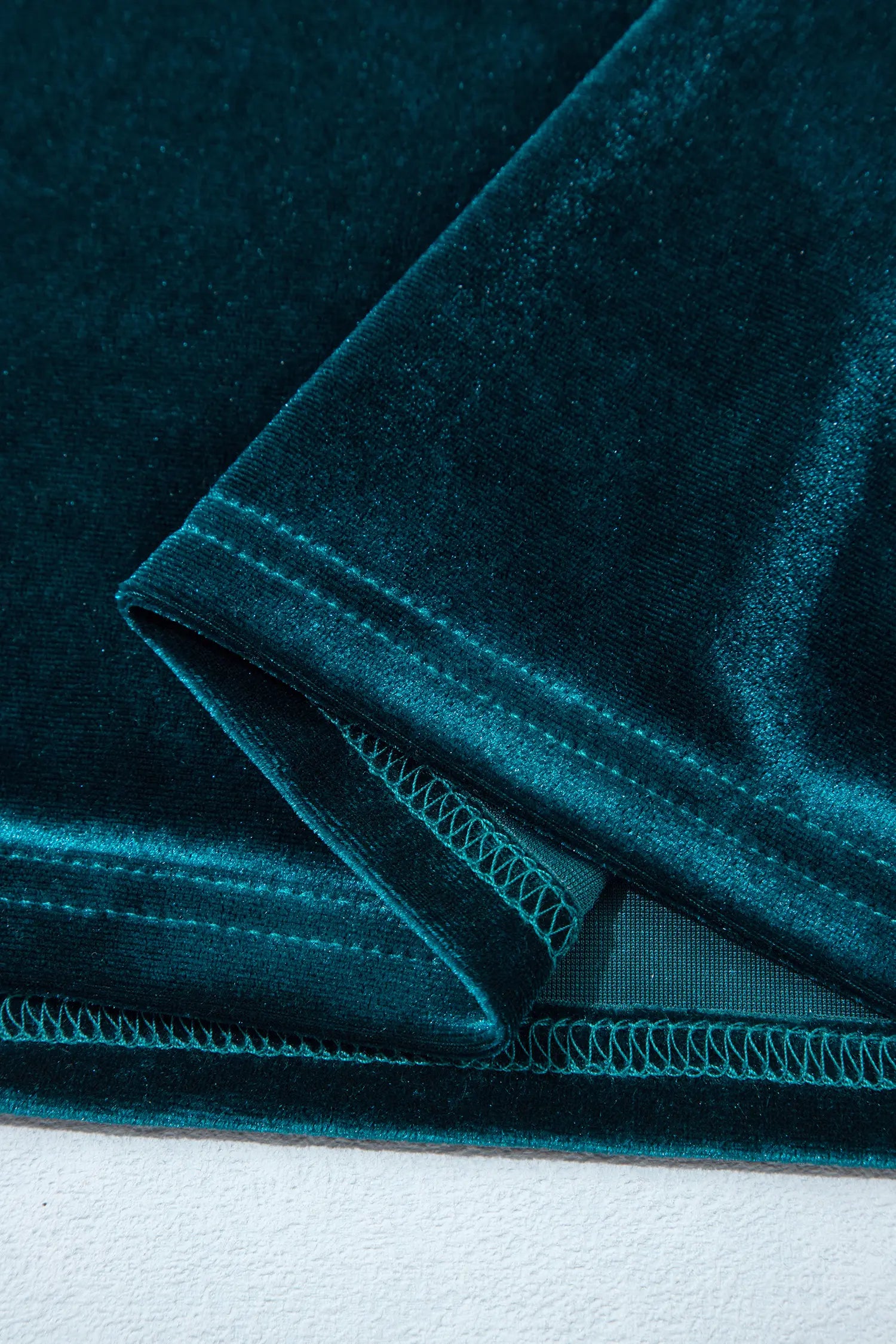 Hem detail on teal stretch velvet mini dress