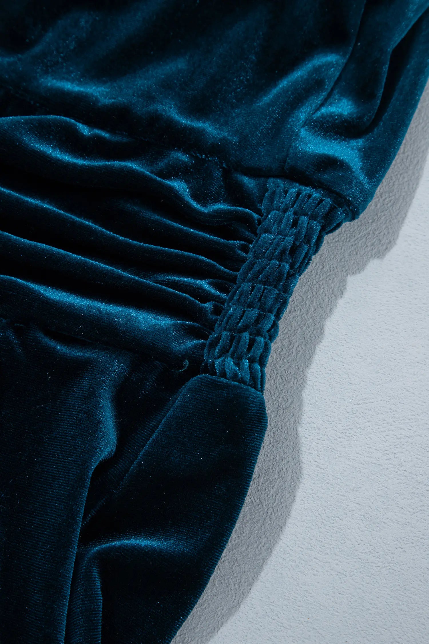Close-up of smocked back waist on teal velvet dress