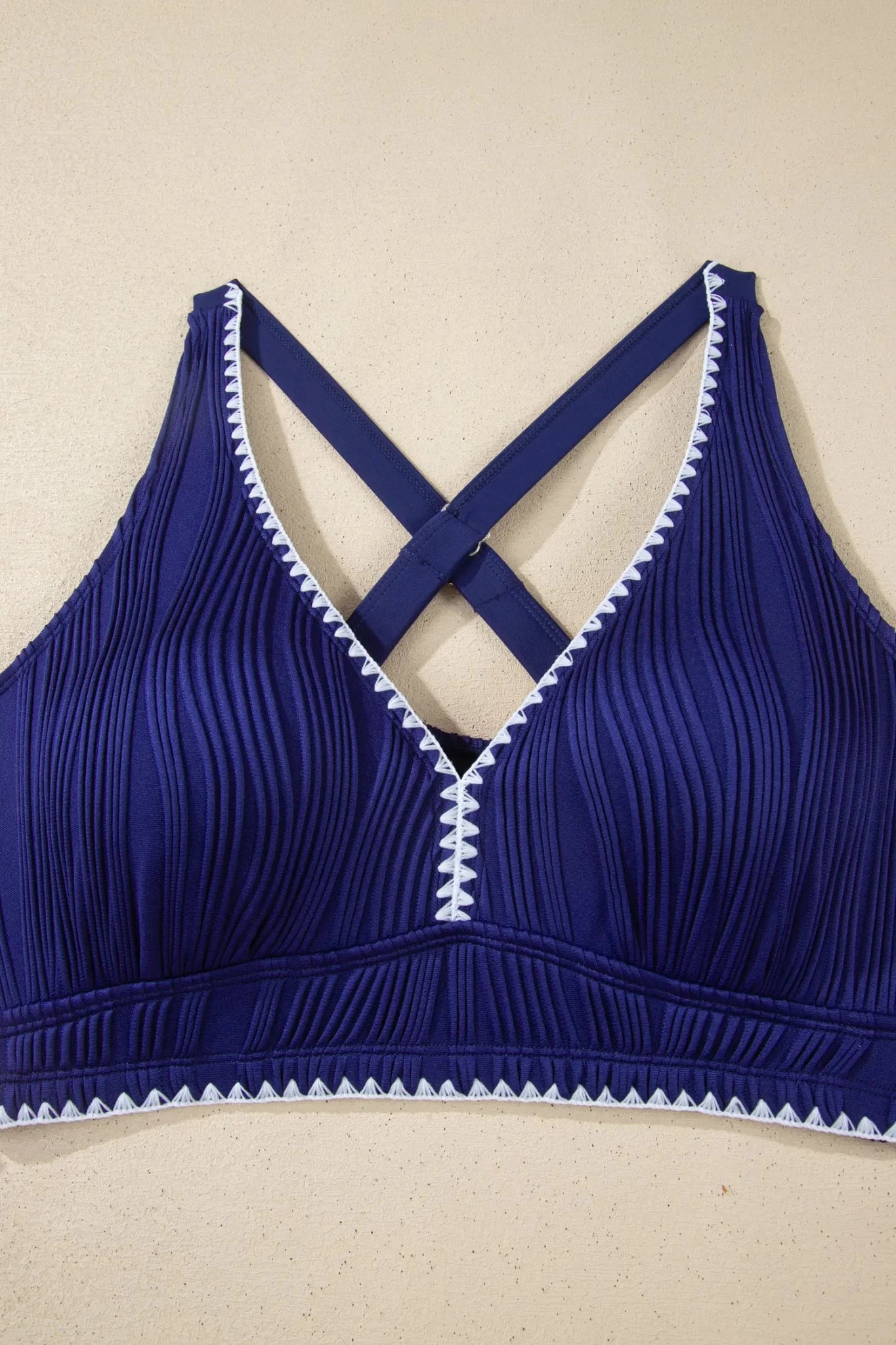 Blue bra with white trim on a beige background