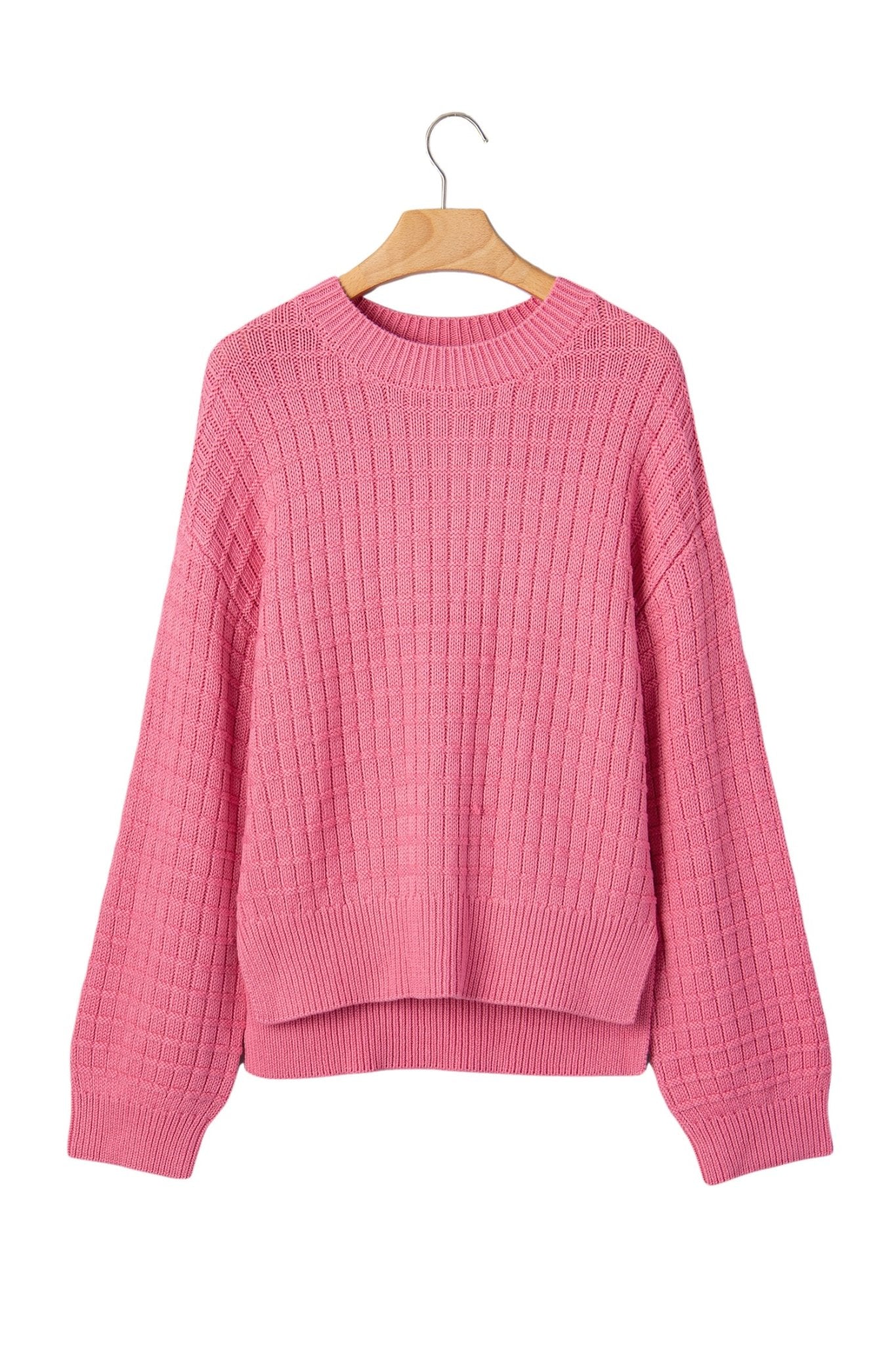 Pink ribbed knit crew-neck sweater with long sleeves on wooden hanger.
