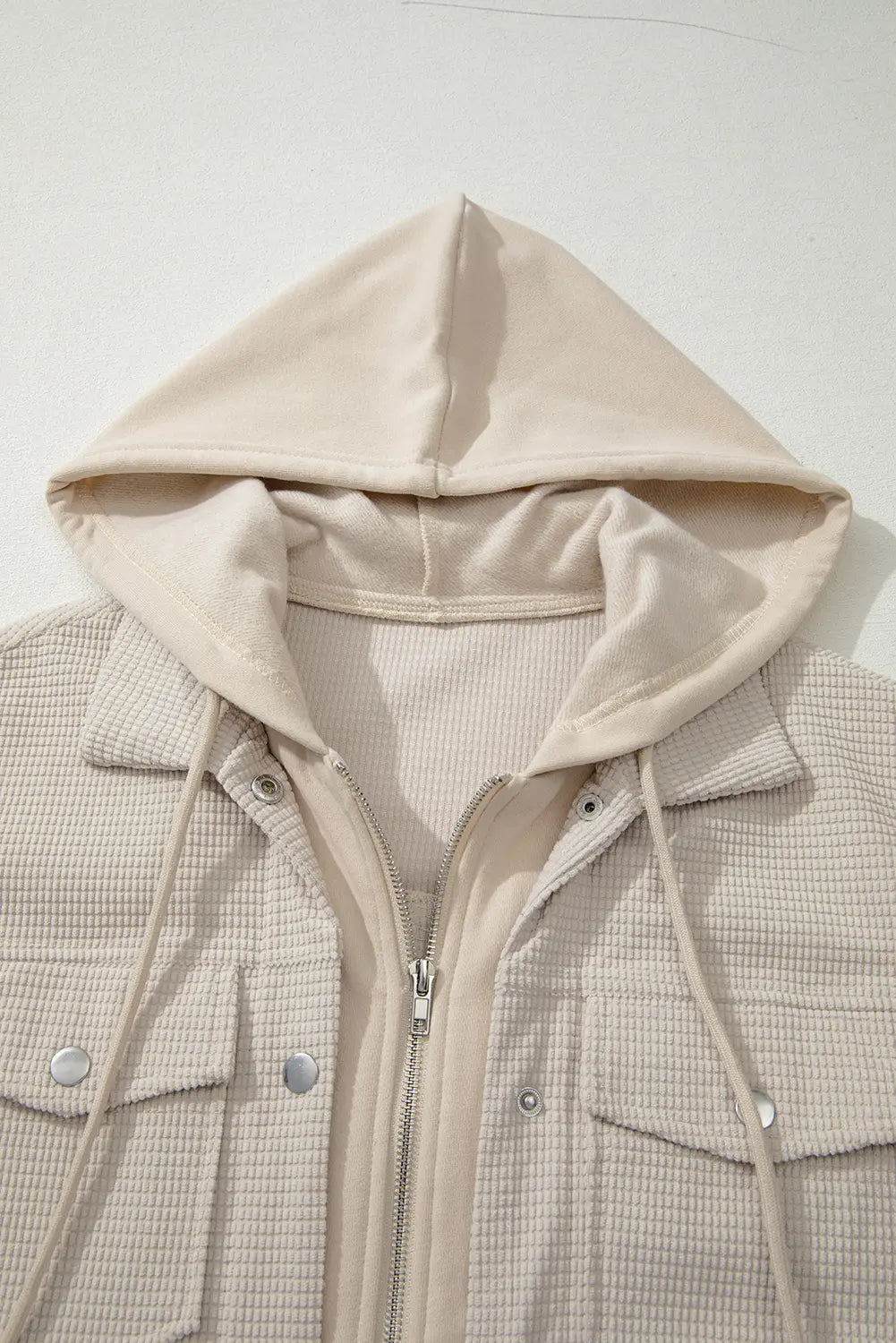 Beige hooded jacket with a checkered pattern on a white background.