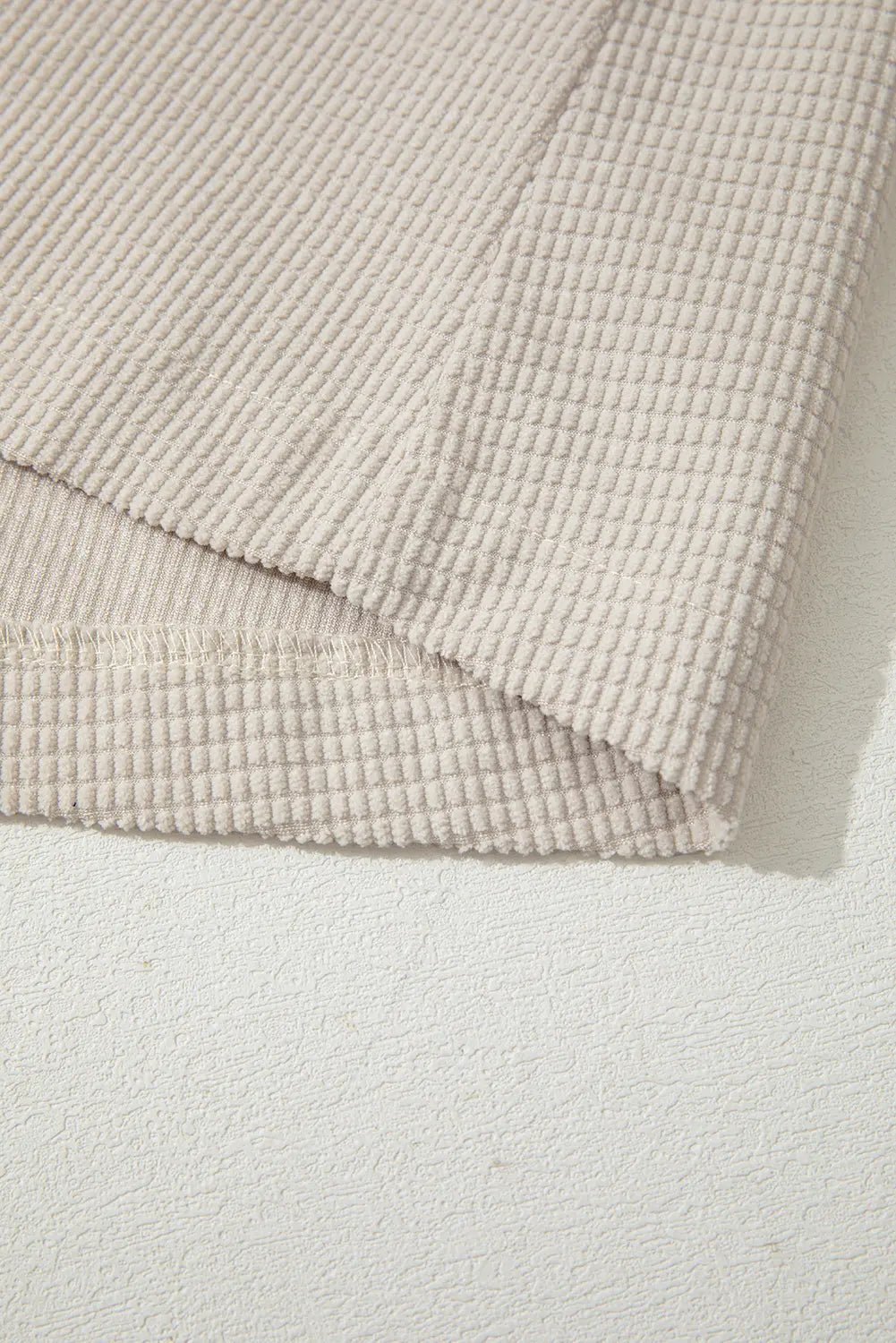 Textured beige towel on a light gray background.
