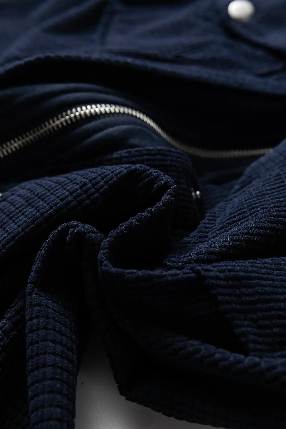 Close-up of a navy blue textured fabric with a zipper