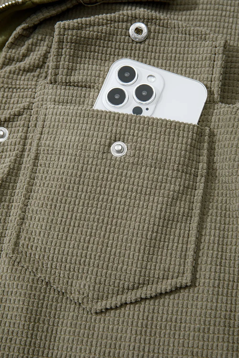 Close-up of a brown textured shirt pocket with a smartphone inside