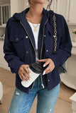 Person wearing a navy blue jacket holding a coffee cup indoors.