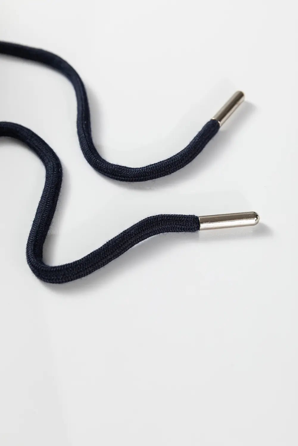 Black shoelaces with silver metal tips on a white background