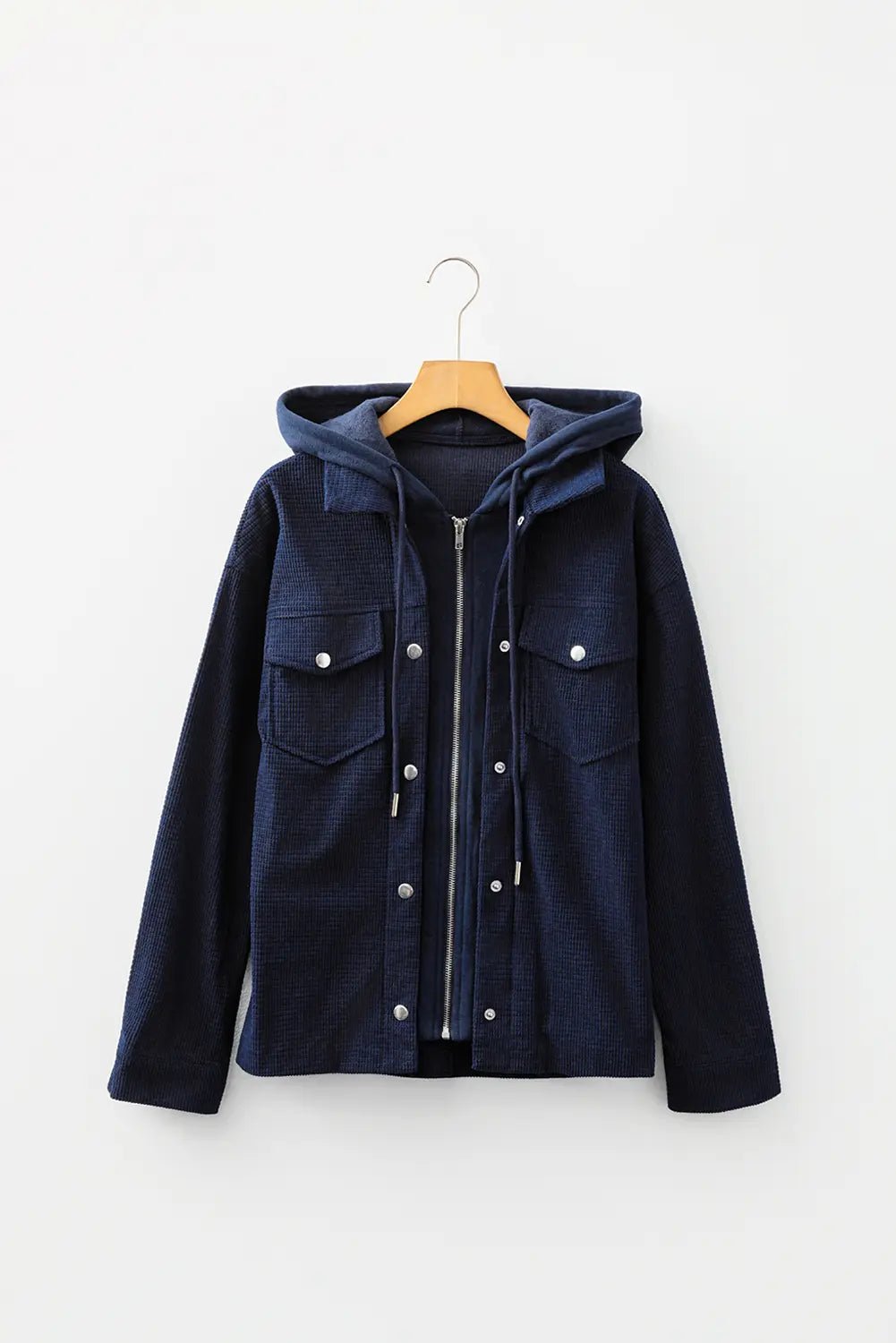 Navy blue jacket with a hood on a wooden hanger against a white background