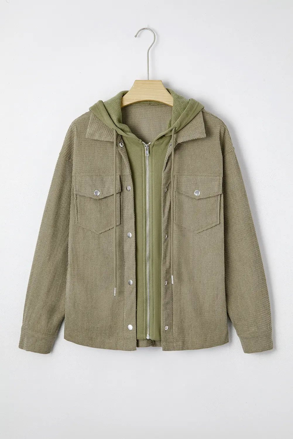 Olive green hooded utility jacket with front zipper and buttons on a wooden hanger.
