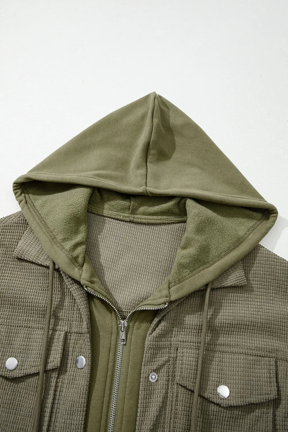 Green hooded jacket with a textured pattern on a white background.