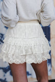 White lace skirt worn by a person with a blurred background