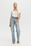 Woman wearing light blue jeans and a white top on a white background